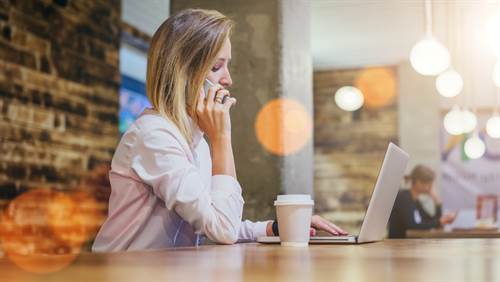 Frau im Business-Outfit im Coffeshop
