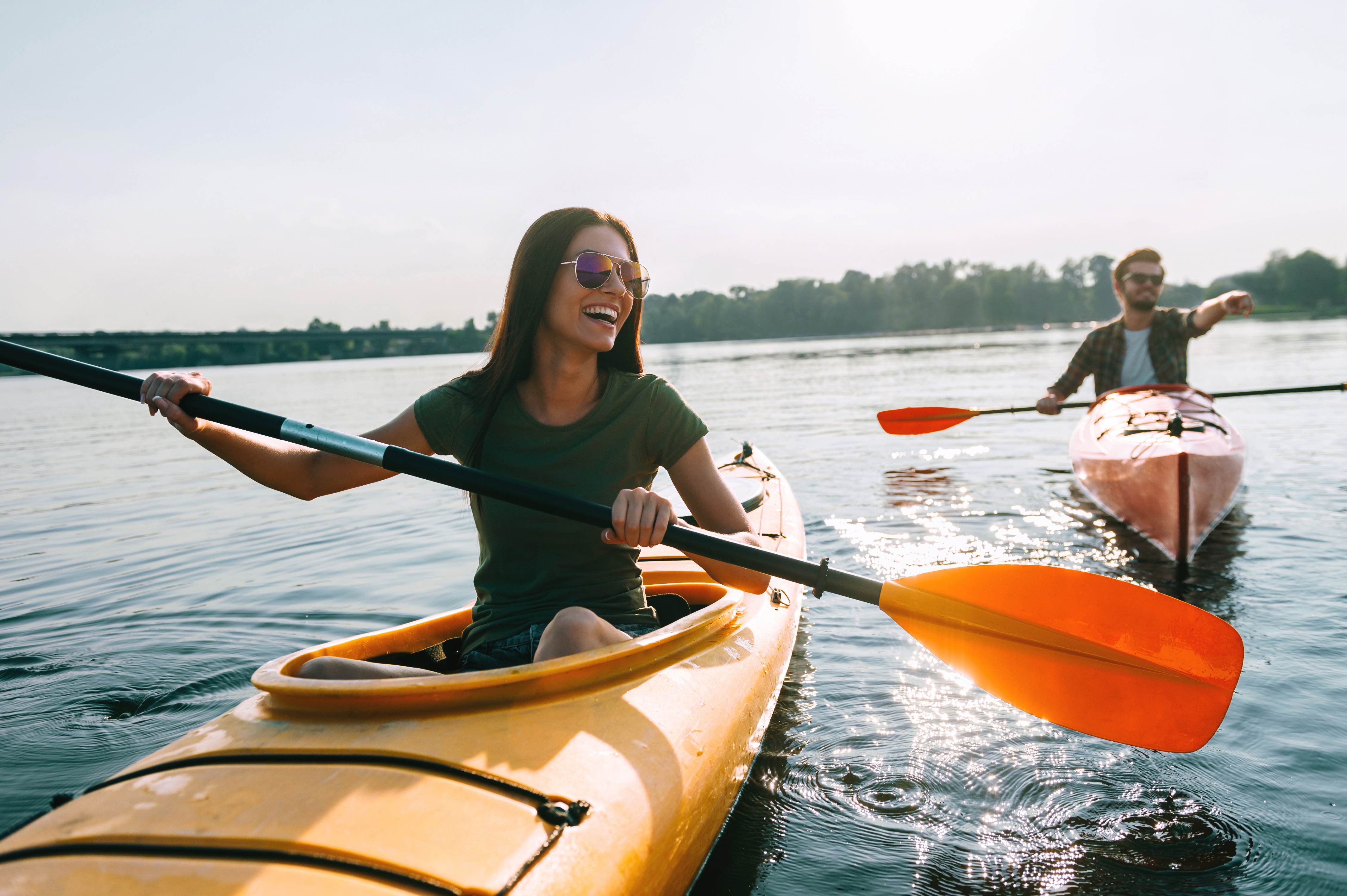 Happy Couple in kayak paddling at sea